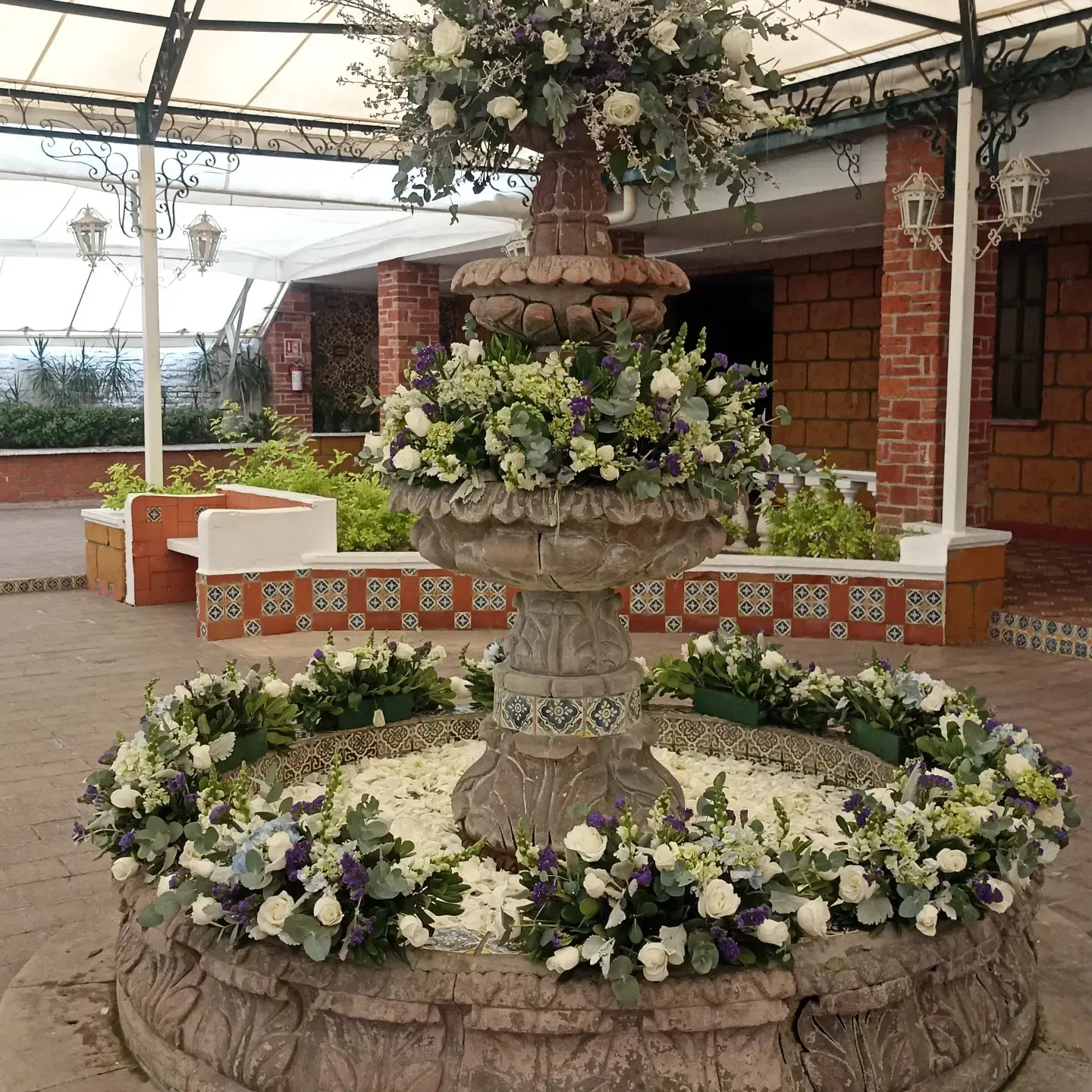 Fuente de cantera con arreglo floral en el Área Las Fuentes
